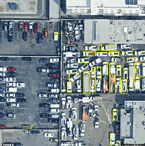 Aerial view of a parking lot with cars and buildingsAI-generated content may be incorrect.